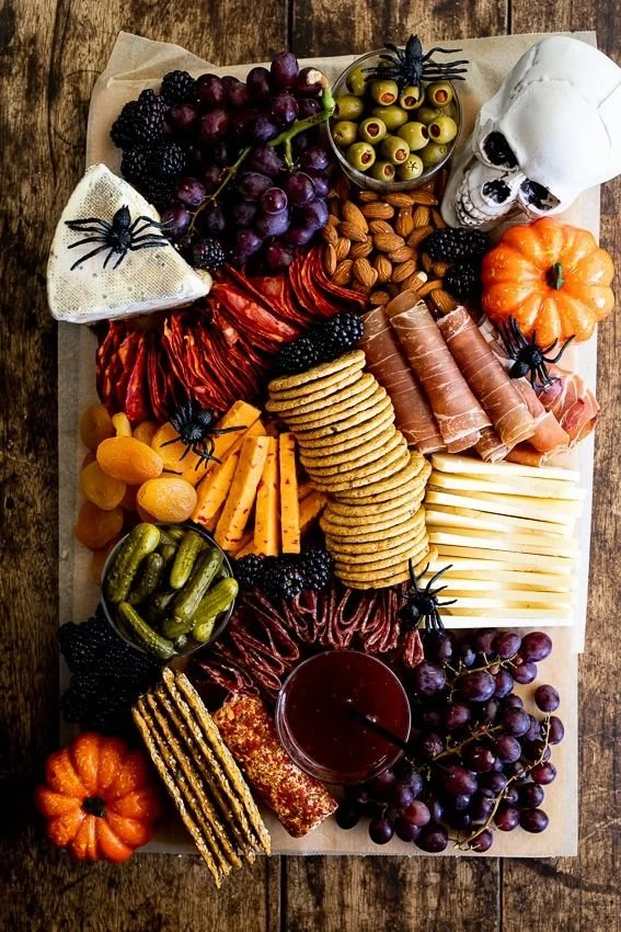 A creatively arranged Halloween charcuterie board featuring festive treats and decorations.