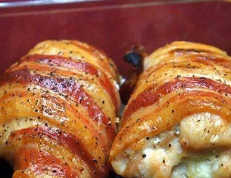 Bacon wrapped chicken breast filled with cream cheese, garnished and ready to serve.