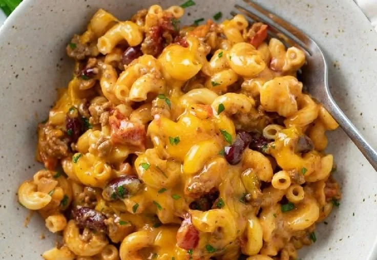 A flavorful bowl of Chili Mac topped with cheese and herbs