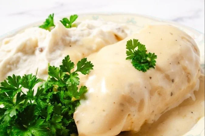Delicious plate of CrockPot Creamy Ranch Chicken with fresh herbs on top
