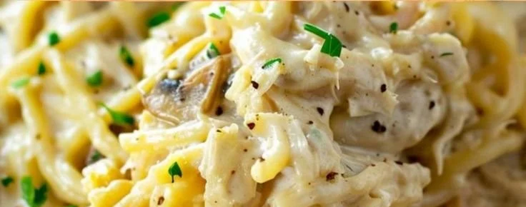 A creamy plate of easy chicken tetrazzini topped with herbs and cheese
