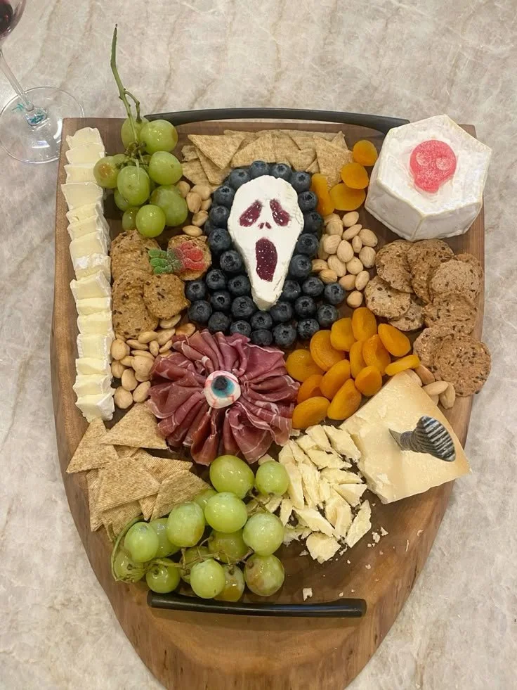 Halloween inspired charcuterie board with spooky treats and fall decor.