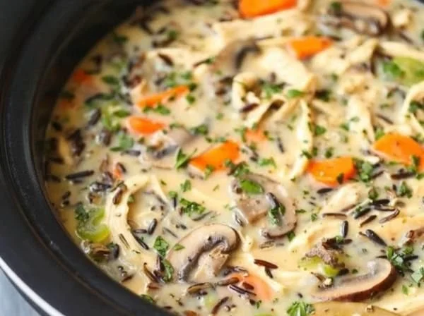 Bowl of Slow Cooker Chicken and Wild Rice Soup topped with herbs