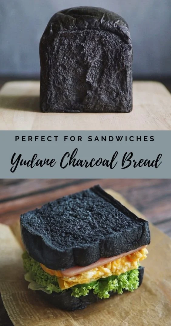 Freshly baked Yudane Charcoal Bread showcased on a rustic wooden table.