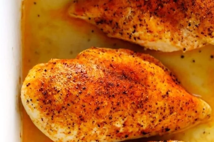 Juicy oven-baked chicken breasts garnished with herbs on a plate